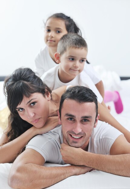 gelukkige jonge familie in hun slaapkamer hebben plezier en spelen in bed