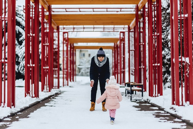 Gelukkige jonge familie loopt met baby op winter straat, moeder, vader, kind