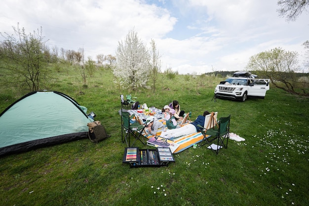 Gelukkige jonge familie moeder en kinderen hebben plezier en genieten van buiten op picknickdeken