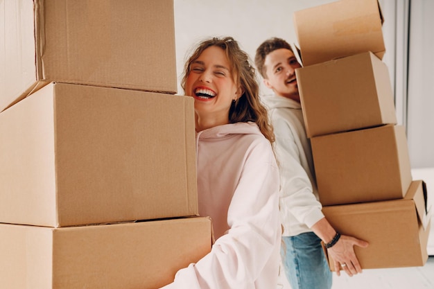 Gelukkige jonge familie paar man en vrouw verhuizen met kartonnen dozen naar hun nieuwe huis appartement