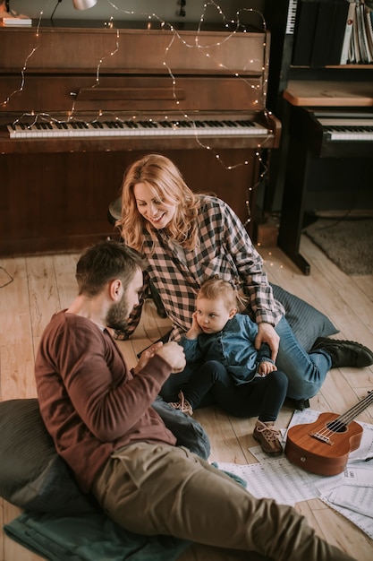 Gelukkige jonge familie spelen op de vloer in de kamer