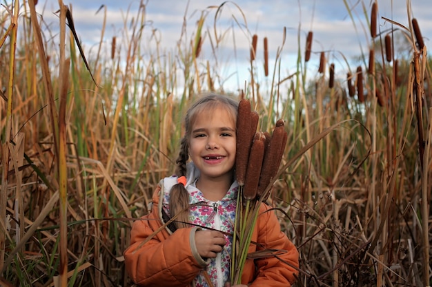 Gelukkige jonge geitjes die pret op het gebied van cattails hebben, ecologieconcept