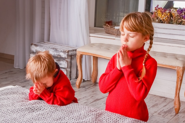 Gelukkige jonge geitjes die thuis voor kerstmis bidden