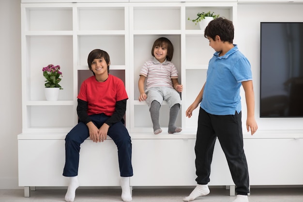 gelukkige jonge jongens hebben plezier terwijl ze poseren op een plank in een nieuw, modern huis