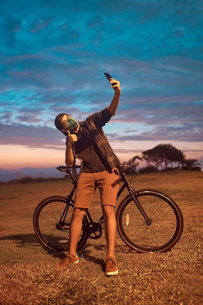 gelukkige jonge man doet selfie naast haar fiets