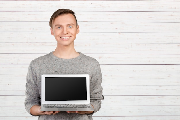 Gelukkige jonge man met laptop