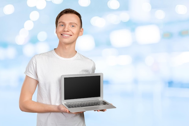 Gelukkige jonge man met laptop