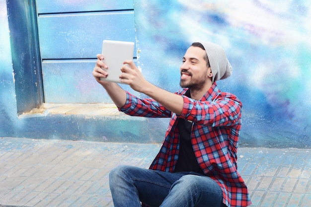 Gelukkige jonge mens die een selfie neemt.