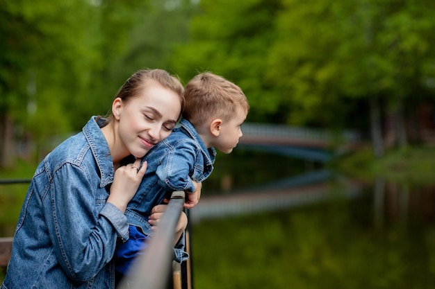 Gelukkige jonge moeder die met haar kleine baby speelt en plezier heeft op een warme lente- of zomerdag in het park Gelukkige familieconcept moederdag