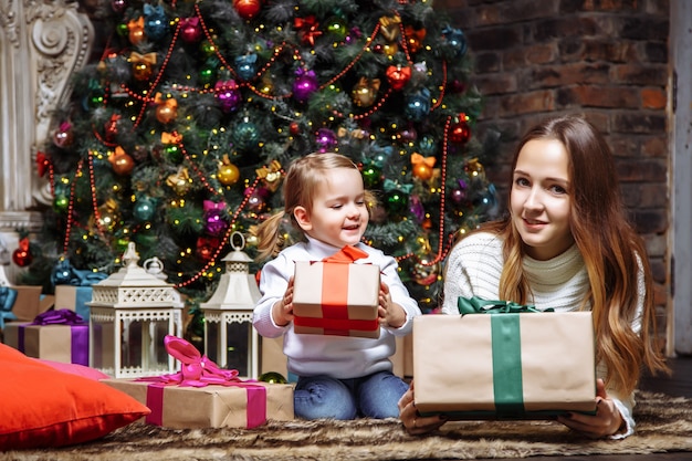 Gelukkige jonge moeder en dochter met Kerstmisgiften