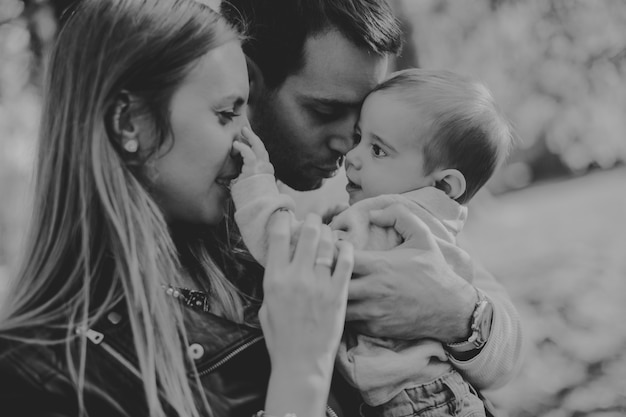 Gelukkige jonge ouders met babyjongen in de herfstpark