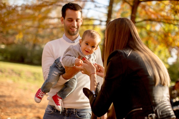 Gelukkige jonge ouders met babyjongen in de herfstpark