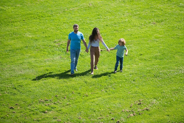 Gelukkige jonge ouders spelen met kind buiten in het park