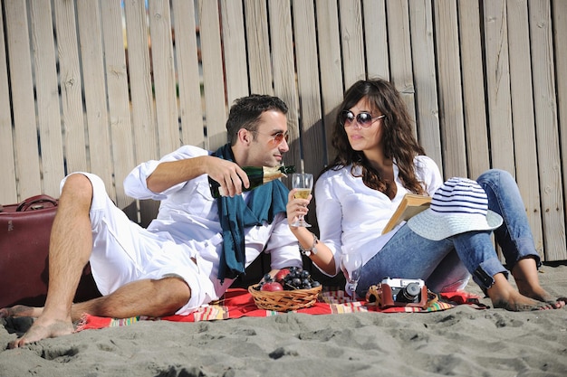 gelukkige jonge paar genieten van picknick op het strand en veel plezier op zomervakanties