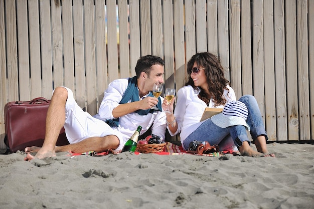 gelukkige jonge paar genieten van picknick op het strand en veel plezier op zomervakanties