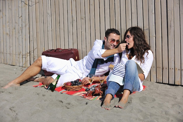 gelukkige jonge paar genieten van picknick op het strand en veel plezier op zomervakanties