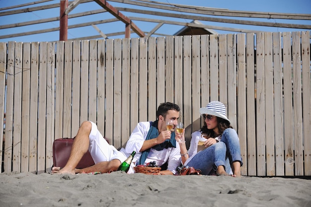 gelukkige jonge paar genieten van picknick op het strand en veel plezier op zomervakanties