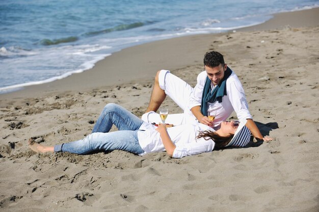 gelukkige jonge paar genieten van picknick op het strand en veel plezier op zomervakanties