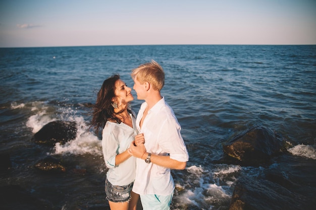 Gelukkige jonge paar verliefd tegen de zee lopen op het strand tegen de blauwe lucht en veel plezier op zomerdag Saamhorigheid liefde familie