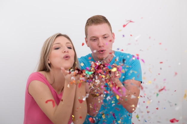 gelukkige jonge romantische paar verliefd vieren en blazen confetti decoraties op nieuwjaar en charisma's party