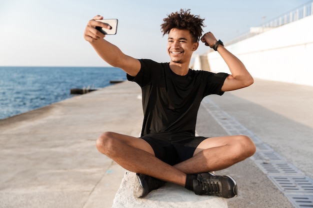 Gelukkige jonge sportman op het strand