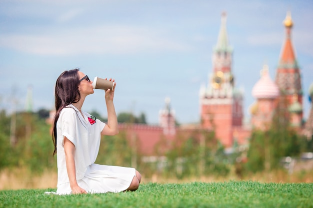 Gelukkige jonge stedelijke vrouw het drinken koffie in Europese stad.