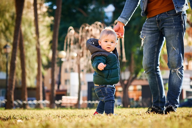 Gelukkige jonge vader die met zijn kleine zoon loopt