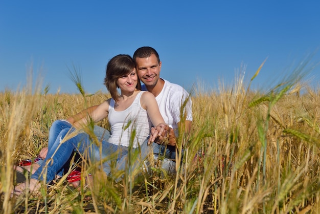 gelukkige jonge verliefde paar hebben romantiek en plezier op het tarweveld in de zomer