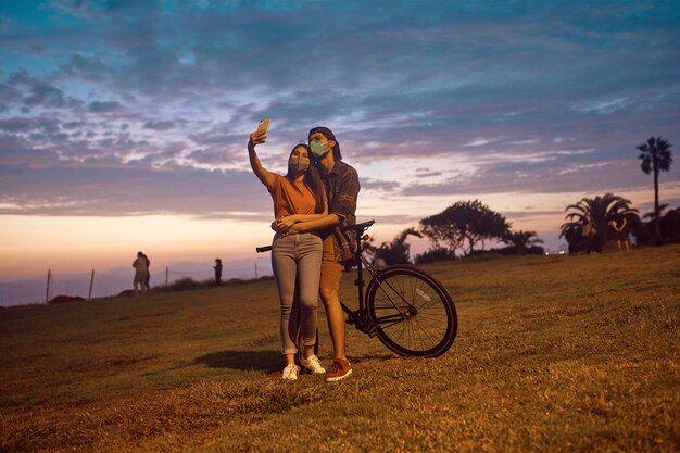 gelukkige jonge verliefde paar nemen selfie samen in het park bij prachtige zonsondergang
