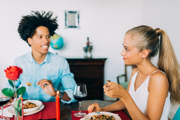 Gelukkige jonge verliefde paar tussen verschillende rassen die een romantisch diner hebben