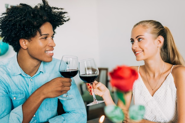 Gelukkige jonge verliefde paar tussen verschillende rassen die een romantisch diner hebben