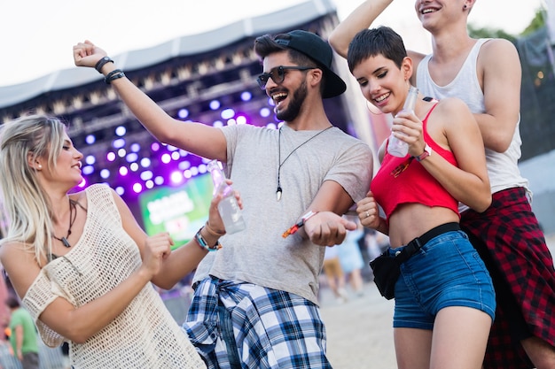 Gelukkige jonge vrienden die plezier hebben op muziekfestival