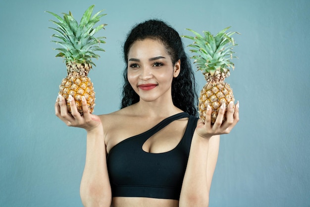 Gelukkige jonge vrouw die ananas toont Ananas fruit vrouw die lacht gezond en vrolijk Mixedrace Aziatisch Kaukasisch model met ananas