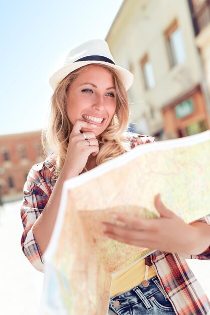 Foto gelukkige jonge vrouw die een stadsplattegrond gebruikt