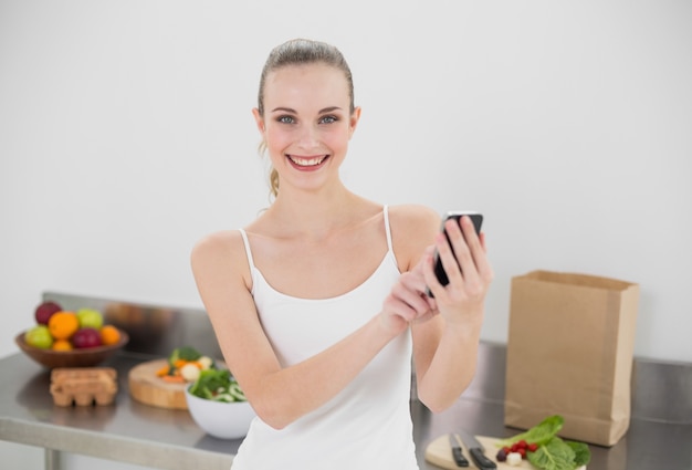 Gelukkige jonge vrouw die het texting verzendt