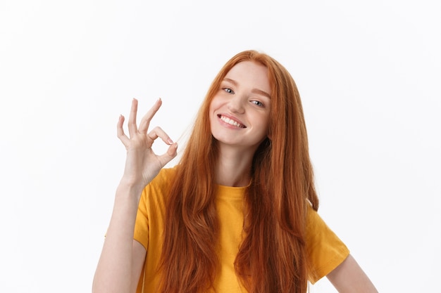 Gelukkige jonge vrouw die ok teken met vingers toont het knipogen