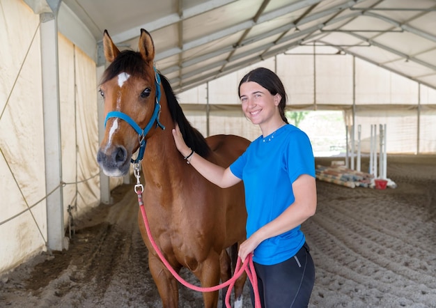 Gelukkige jonge vrouw die paard aait