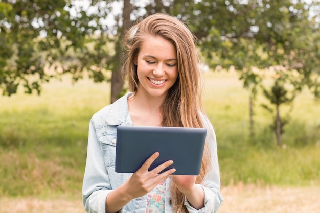 Gelukkige jonge vrouw die tabletpc met behulp van