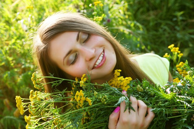 Gelukkige jonge vrouw en wilde bloemen.