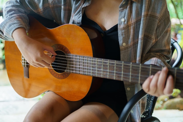 Gelukkige jonge vrouw handen spelen akoestische gitaar muzikant alleen componeren instrumentale lied les op het spelen van de gitaar