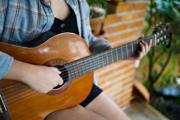 Gelukkige jonge vrouw handen spelen akoestische gitaar muzikant alleen componeren instrumentale liedles over gitaar spelen