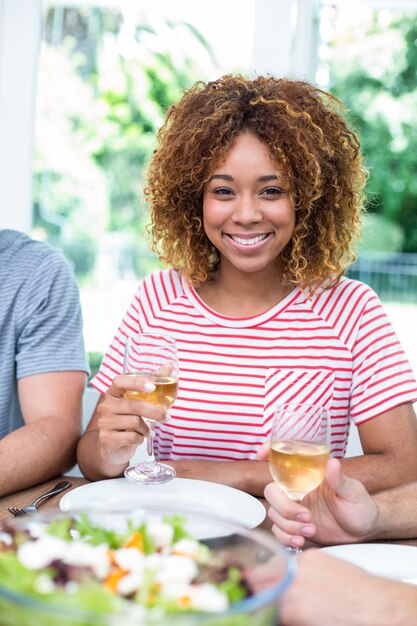 Foto gelukkige jonge vrouw het drinken wijn met vrienden