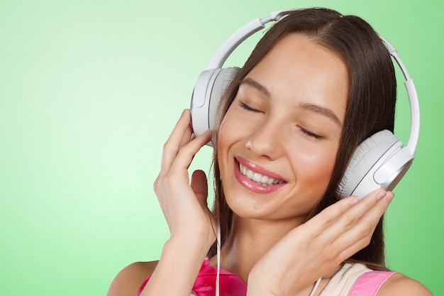 Gelukkige jonge vrouw het luisteren muziek met hoofdtelefoons
