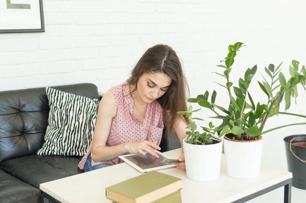 Gelukkige jonge vrouw met tabletpc op bank