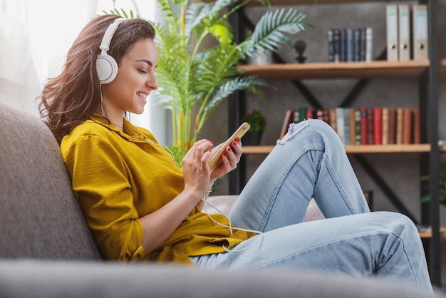 Gelukkige jonge vrouw ontspannen en luisteren naar muziek met haar smartphone