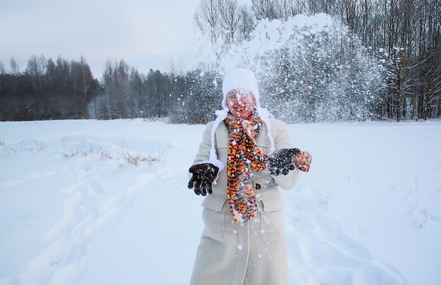 Gelukkige jonge vrouw op besneeuwd veld