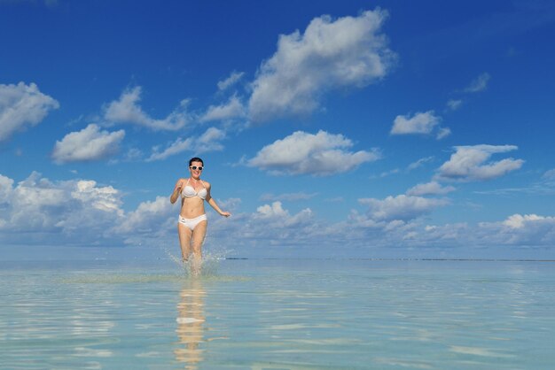 gelukkige jonge vrouw op zomervakantie op prachtig tropisch strand veel plezier, geniet en ontspan