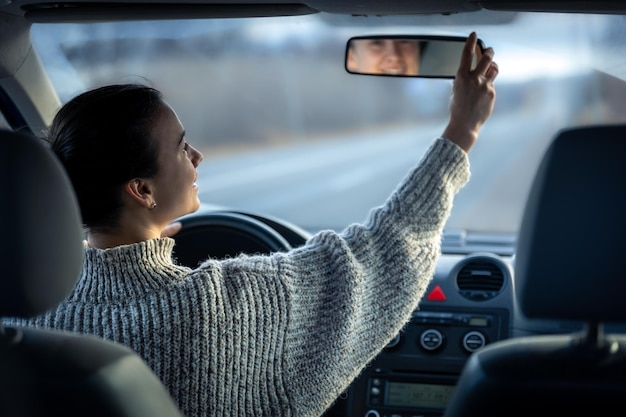 Gelukkige jonge vrouw rijdt in een auto van binnenuit