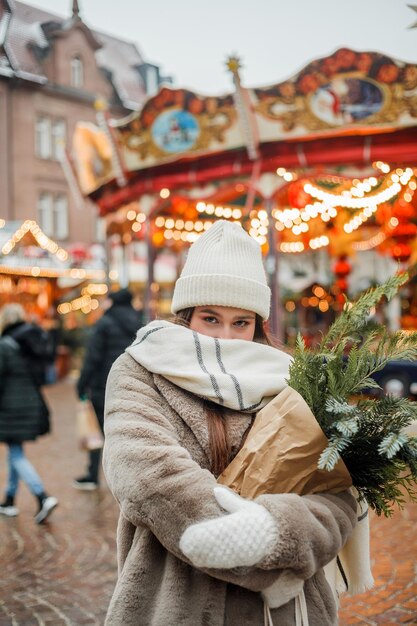 Gelukkige jonge vrouw van Europees uiterlijk op de kerstmarkt in Duitsland Festive stad Decor Nieuwjaar Wintervakantie