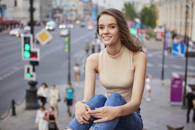 Gelukkige jonge vrouw zit in het centrum tijdens het wandelen